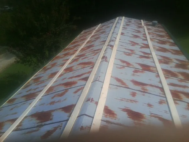 Rusted metal roof panels with new wood purlins before replacement — Storm Damage Roof Repair in Cresson by Roofing Brothers