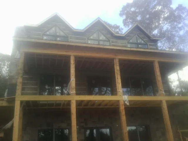 Dormers and porch framing on a large log home under construction — Roof Coating work by our crew in Cresson
